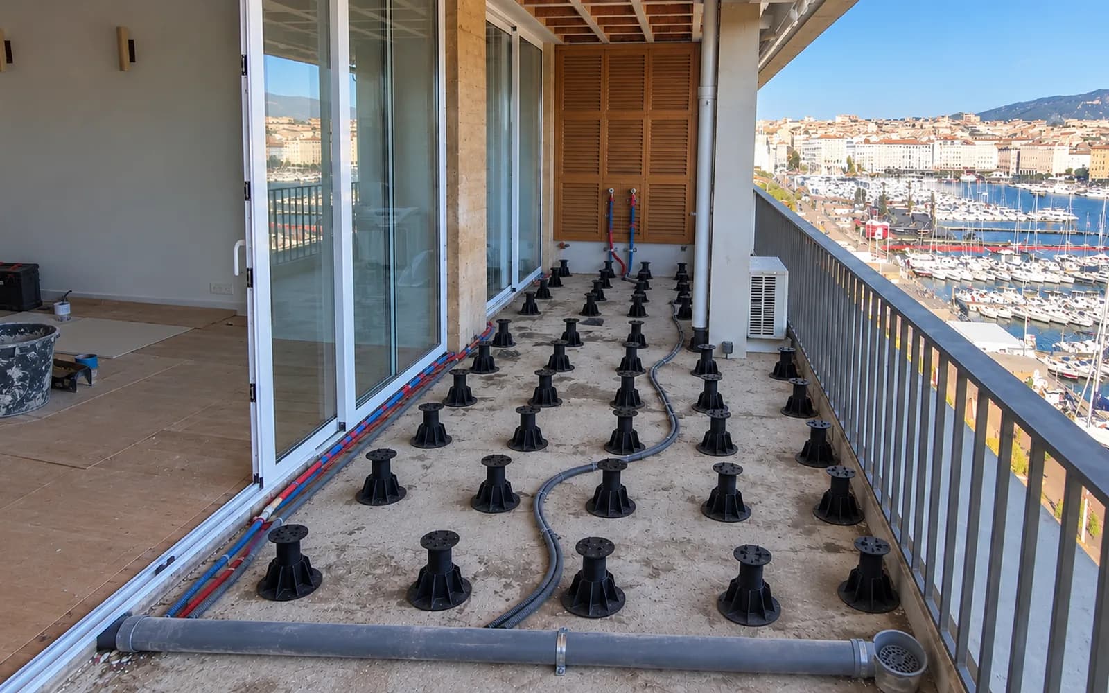 Terrasse carrelée sur plots, vue sur le port — avant travaux